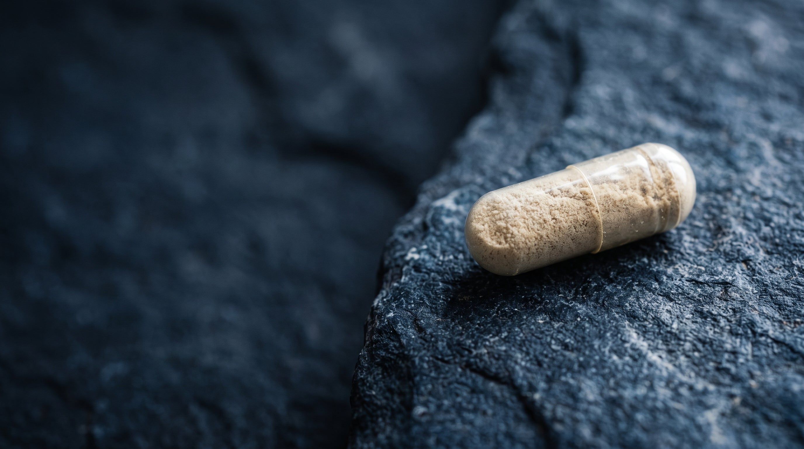 A single Novium-9 capsule resting on dark slate